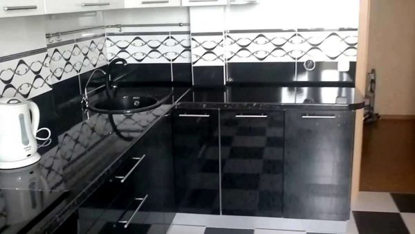 белая кухня с чёрной столешницей и фартуком